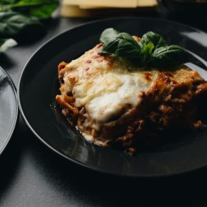 Mouth-watering lasagna topped with fresh basil, capturing the essence of Italian cuisine.